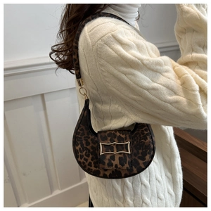Detail of leopard print hobo bag with gold geometric buckle on a textured crescent bag