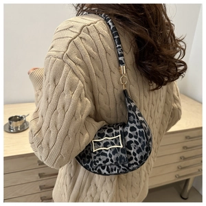 Detail of leopard print crescent bag featuring gold geometric buckle and soft texture