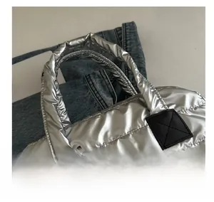 Détail du sac à main matelassé argenté avec poignées renforcées et texture métallique