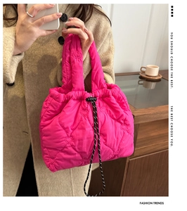 Detail of pink quilted tote bag showing heart embroidery and drawstring closure
