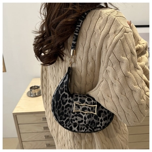 Chic leopard print crescent shoulder bag with golden buckle styled on model