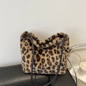 Grand sac cabas en fausse fourrure léopard avec bandoulière noire sur un banc en cuir