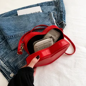 Detail showing internal capacity of the red heart-shaped leather crossbody bag