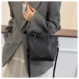 Close-up of black PU leather bucket bag with gold hardware and brand lettering