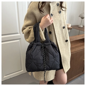 Close-up of black quilted heart-pattern handbag with stylish drawstring closure details