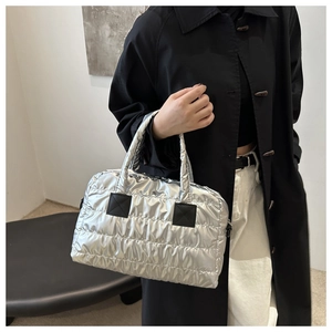 Détail du sac cabas en nylon argenté matelassé avec écussons noirs et texture bouffante