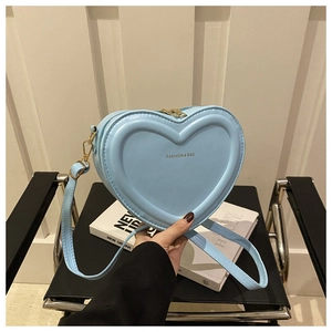 Detail of light blue heart-shaped PU leather bag with golden zipper and logo text