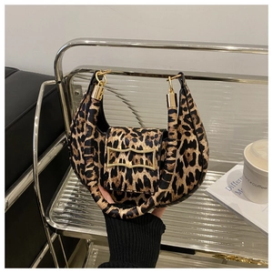 Detail of leopard print crescent bag featuring premium golden metal buckle and leather handle