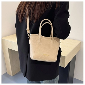 Detail of beige mini bucket bag with gold buckles and adjustable shoulder strap