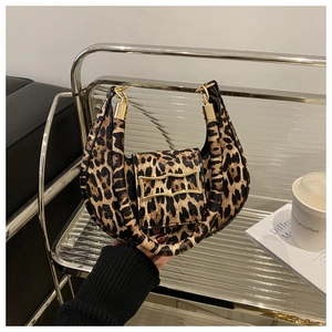 Detail of leopard print handbag featuring a gold buckle and cylindrical handle texture