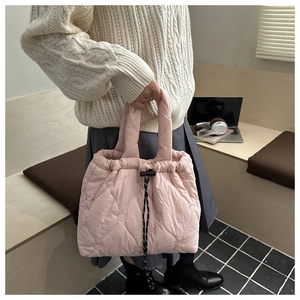 Detail of pink quilted tote bag showing heart-shaped stitching and drawstring closure