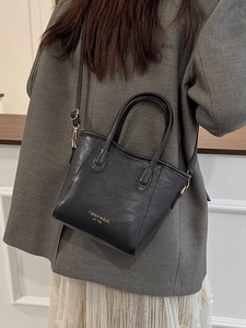 Classic black leather basket bucket bag for women with dual handles and crossbody strap