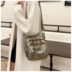 Detail of champagne gold quilted crossbody bag with metallic finish and multi-zipper pockets