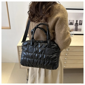 Vue détaillée d'un sac cabas rembourré noir avec texture en nylon et bandoulière large