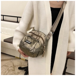 Close-up of metallic bronze quilted crossbody bag featuring a FASHION label detail