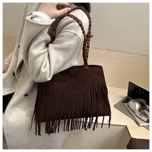 Detailed view of brown suede tassel tote bag with woven handles and fringe design