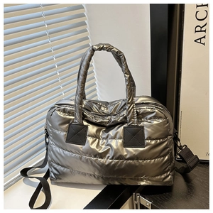 Détail du sac matelassé argenté avec poignées souples et bandoulière en nylon