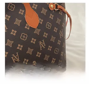 Close-up of the vintage pattern tote bag with vibrant orange handles and metal hardware