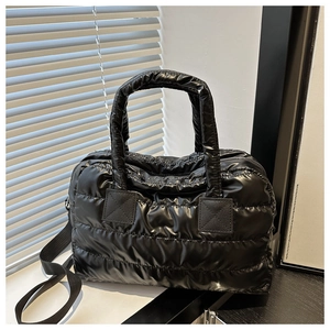 Détail du nylon matelassé brillant et du zip argenté sur ce sac à main bouffant noir