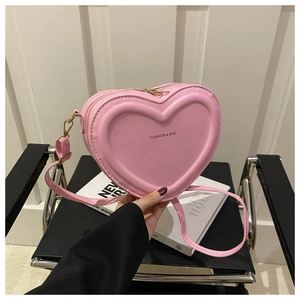 Pink heart-shaped leather crossbody bag featuring embossed Fashion & Bag text detail