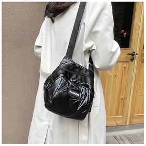 Fashionable black quilted down fabric crossbody bag with wide strap on a model