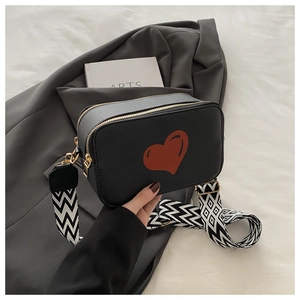 Detail showing litchi texture leather camera bag with heart and geometric strap