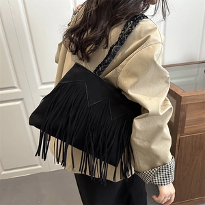 Fashionable black tassel shoulder bag with braided straps and a stylish scalloped edge design