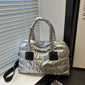 Sac Boston matelassé argenté chic avec poignées rembourrées et bandoulière noire réglable