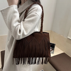 Brown bohemian tassel tote bag with woven handles and geometric detail on shoulder