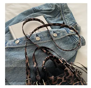 Detailed view of the chic leopard print handbag featuring a slim strap and silver metal buckle