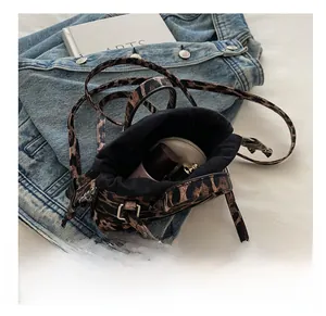 Detail view of leopard print bucket bag interior showing makeup storage capacity
