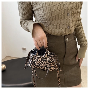 Detail of leopard print mini handbag featuring silver hardware and drawstring closure