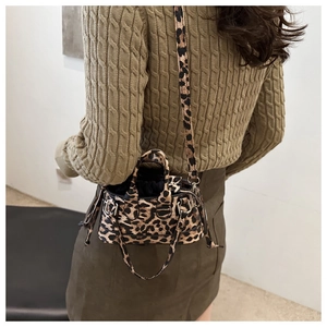 Detail view of stylish leopard print crossbody bag worn by a model in autumn outfit
