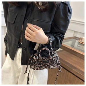 Detail of leopard print crossbody bag with drawstring closure and matching shoulder strap