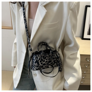 Detail of French leopard print mini bag showing textured finish and styling with white blazer