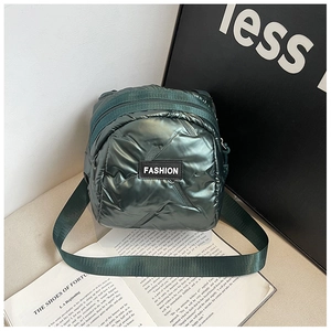 Macro shot of dark green quilted metal-texture bag with Fashion label and wide strap