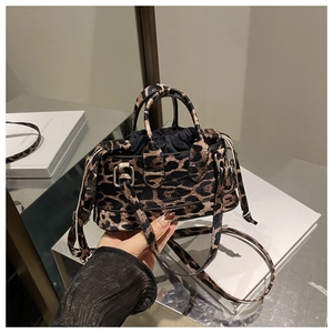 Close-up of leopard print handbag featuring high-gloss silver hardware and drawstring closure