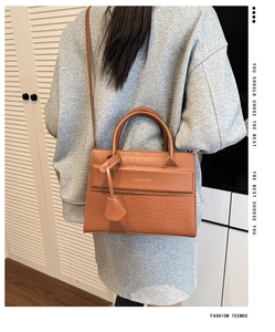 Caramel crocodile embossed handbag with adjustable strap shown in a real-life styling view