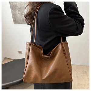 Brown large capacity tote bag with vintage pleated texture shown in a casual lifestyle setting