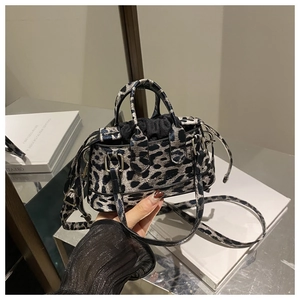 Detail view of leopard print mini tote bag with dual handles and black drawstring closure