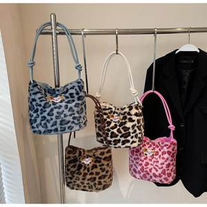 Dettaglio di quattro borse in peluche leopardate con eleganti manici annodati in pelle PU