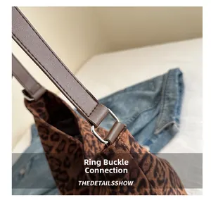 Detail of leopard print tote bag showing leather strap with silver metal buckle connector