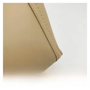 Detailed macro view of khaki leather texture and neat stitching on this commuter shoulder bag