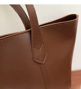 Detail shot of the stitching and edge finishing on the dark brown leather tote bag