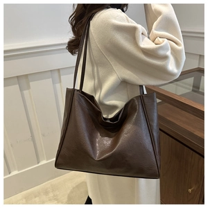 Detail of dark brown tote bag in oily wax leather texture for commuting and casual style