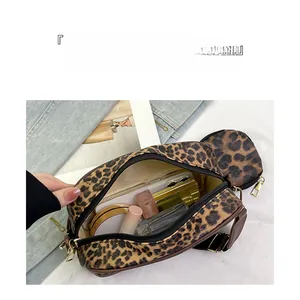 Detailed view of leopard print bag interior with cosmetics, lipstick, and smartphone