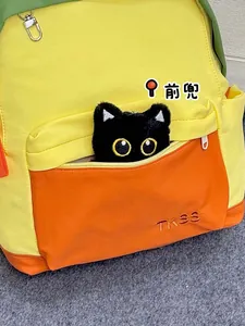 Close-up of front pocket with cute black cat design and embroidered logo on school bag