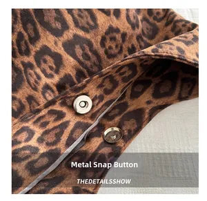 Macro shot of silver magnetic snap closure and leopard print plush fabric detail