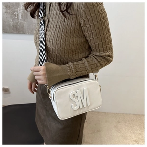 Detail of white rectangle crossbody bag with SM logo and geometric wide fabric strap