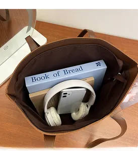 Macro view of spacious brown tote bag interior with zipper pocket and laptop space